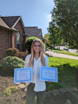 Ashlyn holding two certificates