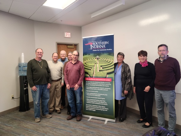 Center For Communal Studies Advisory Board members pose with a stand up banner featuring New Harmony labyrinth