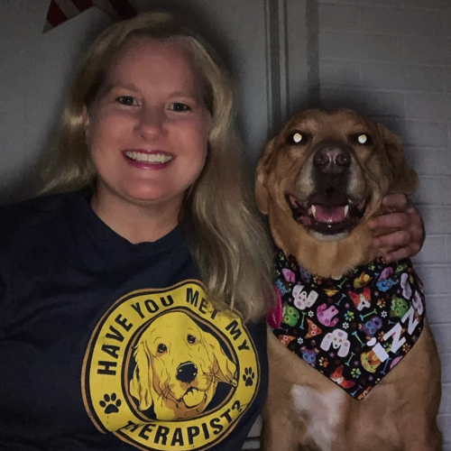 smiling woman with smiling golden retriever dog wearing a bandana