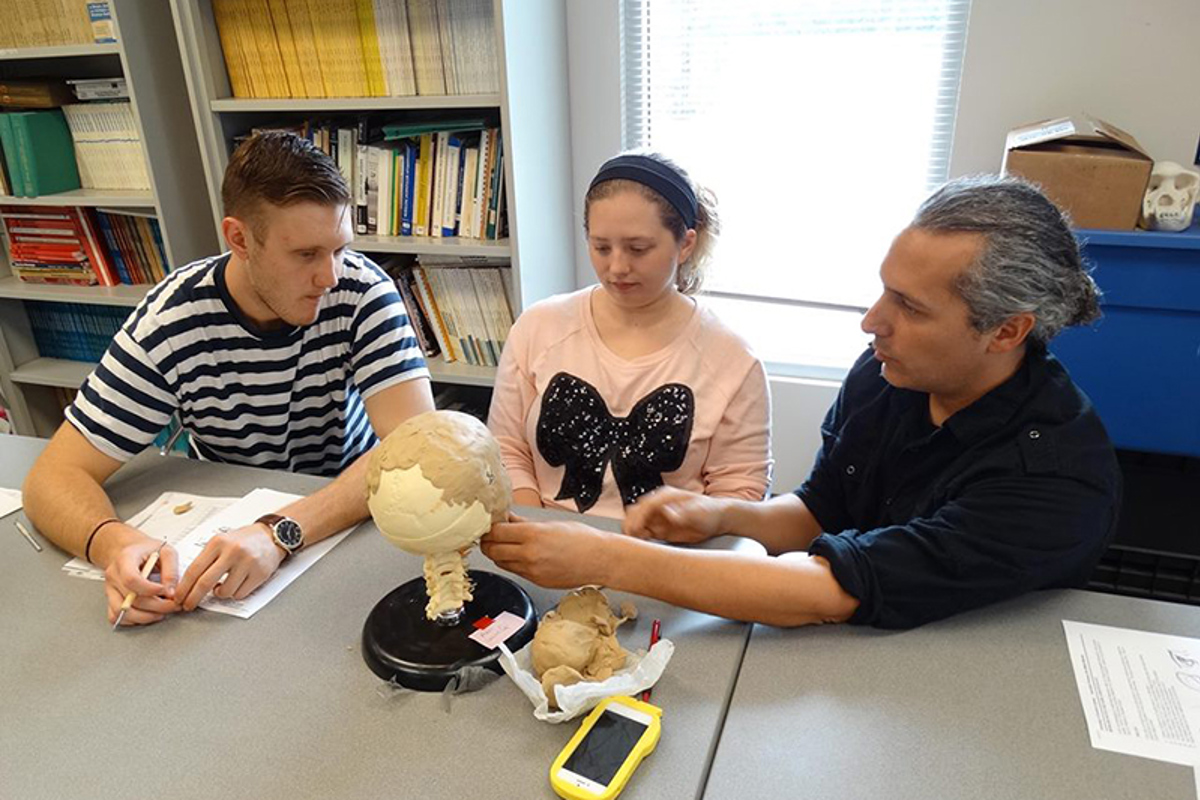 Millard-Mendez works with Dr. Susan Spencer's students on a facial reconstruction project using clay.
