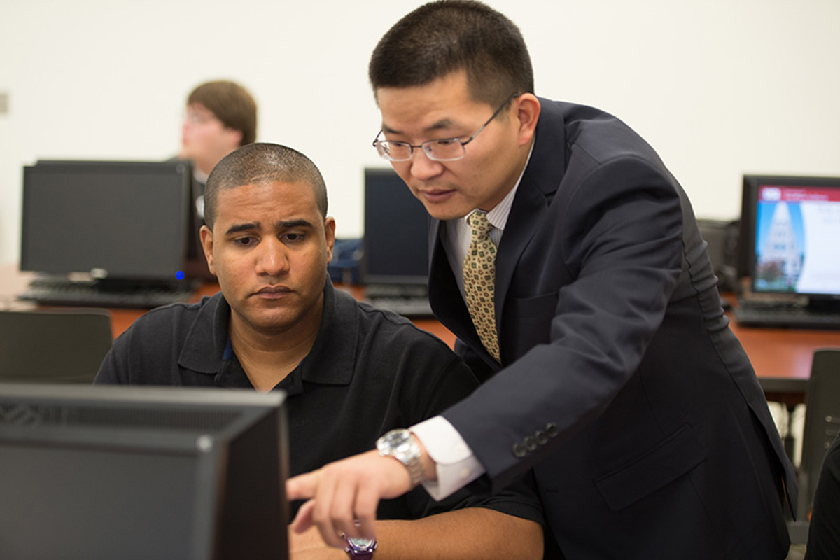 Dr. Gongjun Yan (right) assists a student