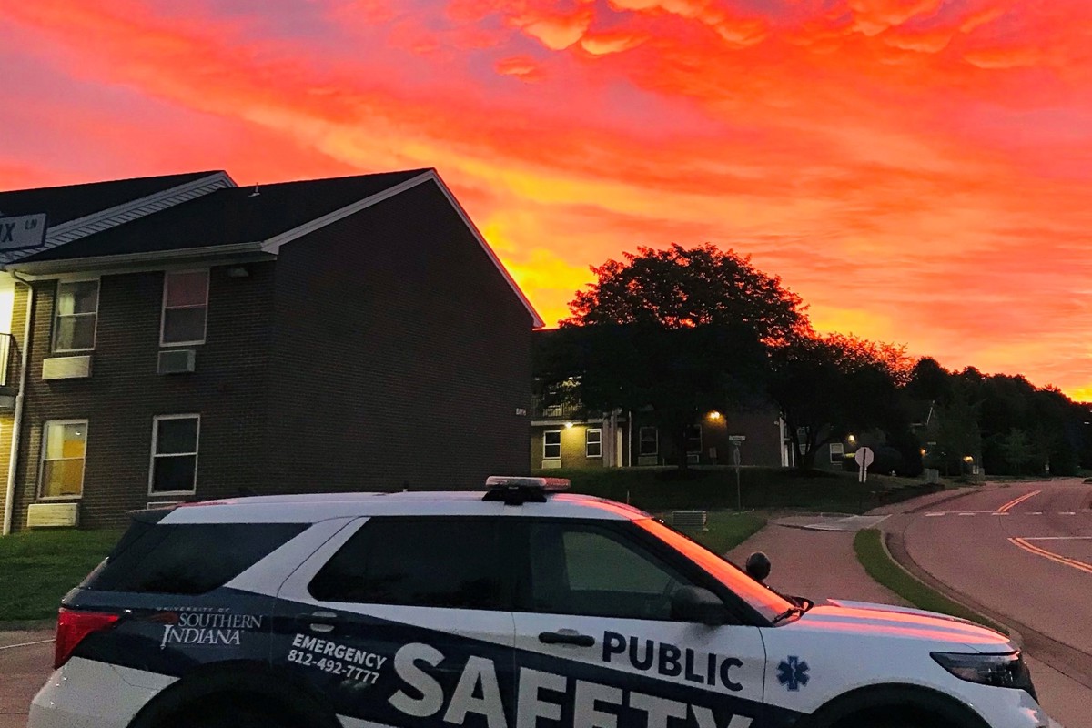 A USI Public Safety vehicle sits in front of a sunset on campus in summer 2022.