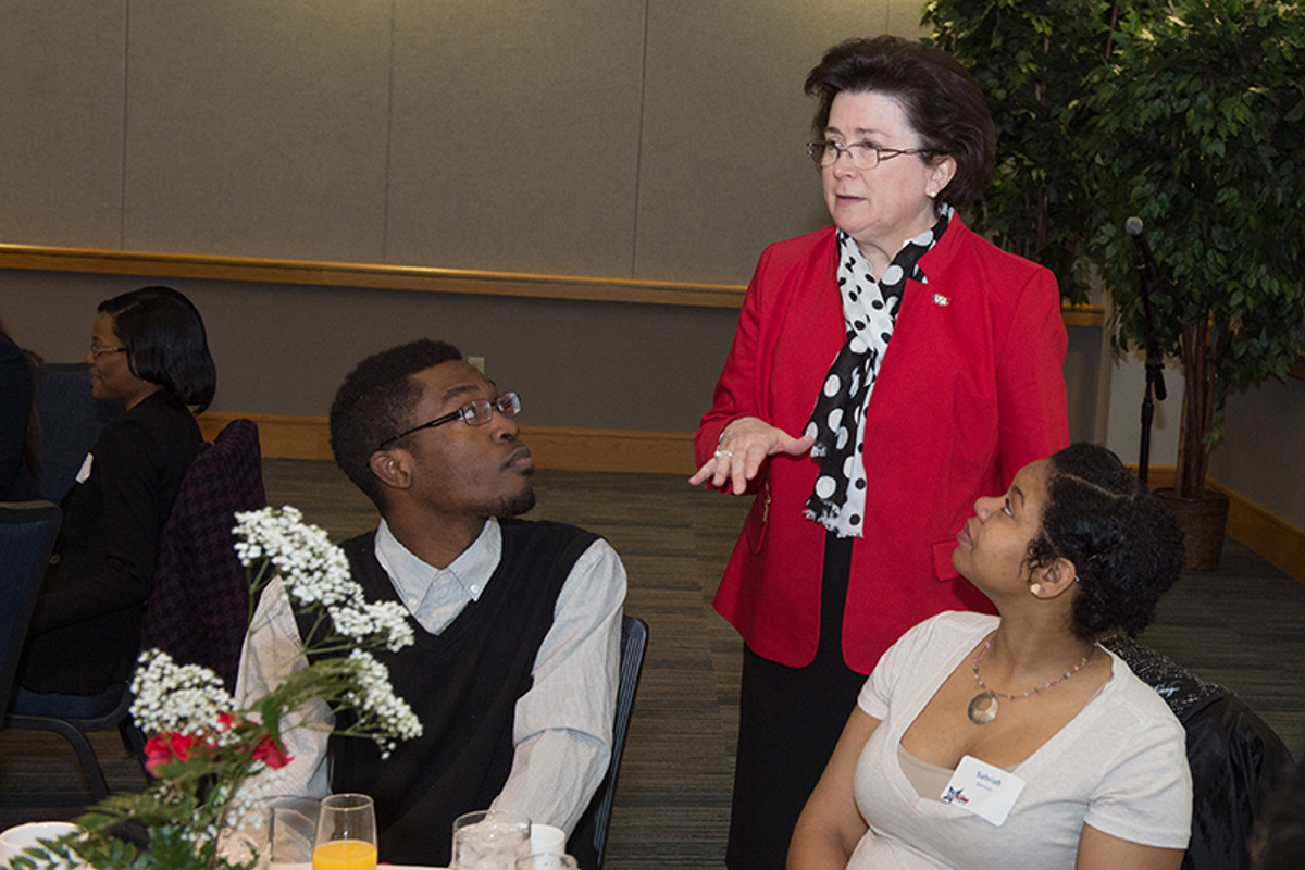 President Linda L.M. Bennett (standing) socializes with guests.