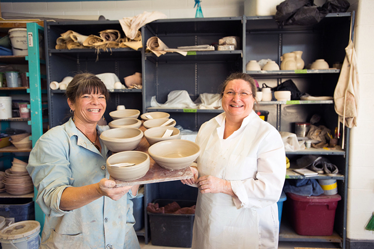 Al Holen and Gloria Butz, biology laboratory supervisor, show off freshly made bowls.