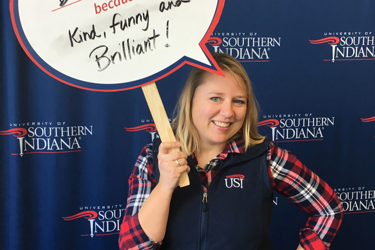 Brandi Hess holds a sign displaying the name of her USI role model, Dr. Linda L. M. Bennett, at a University event
