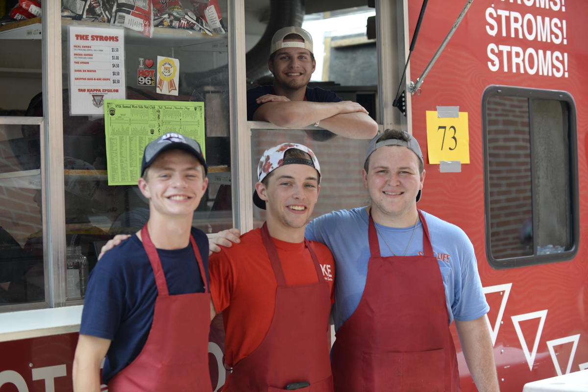Members of Tau Kappa Epsilon smile in front of their Fall Festival booth