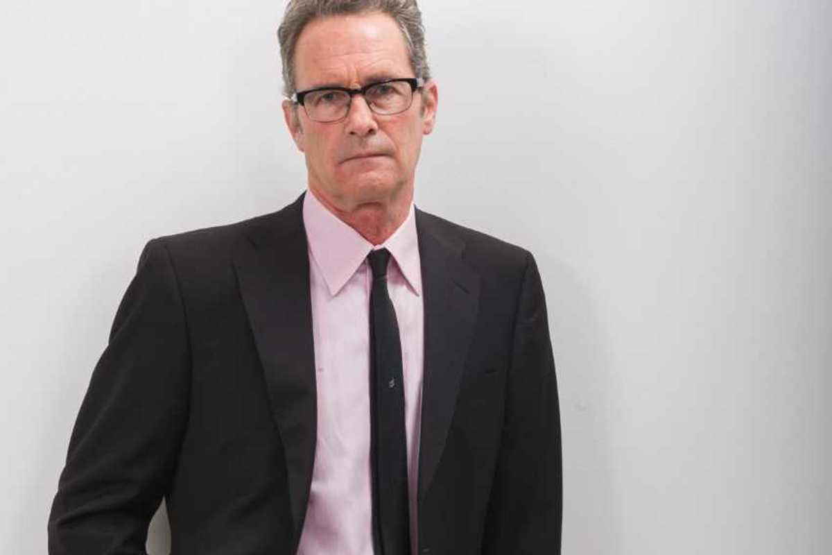 Matthew Graham stands in front of a white wall