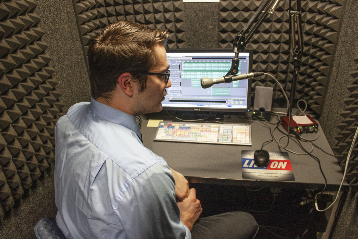 Student working in a recording booth at 95.7 The Spin