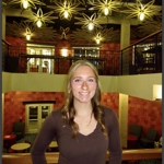 Casual portrait of Ally Patrick standing in the Fireside Lounge at USI
