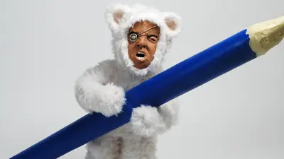 Sculpture, figure in bear suit holding pencil
