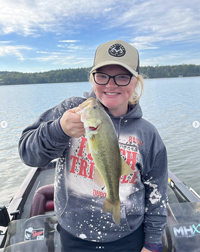 Female USI Bass Fishing team member holding the bass fish she cauth