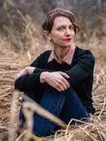 Amie Whittemore standing by a pond in the woods