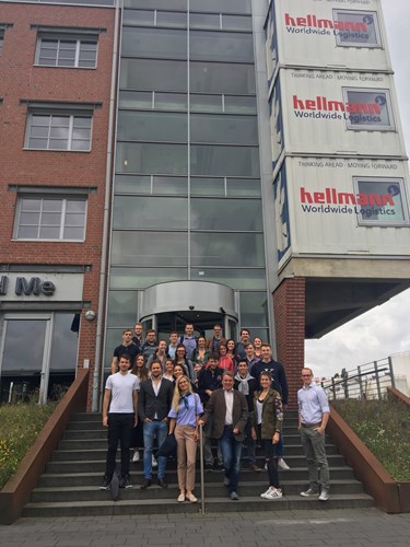 People on steps in front of a high rise building