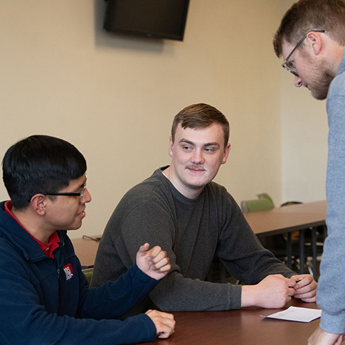 USI management students seated at a table having a conversation