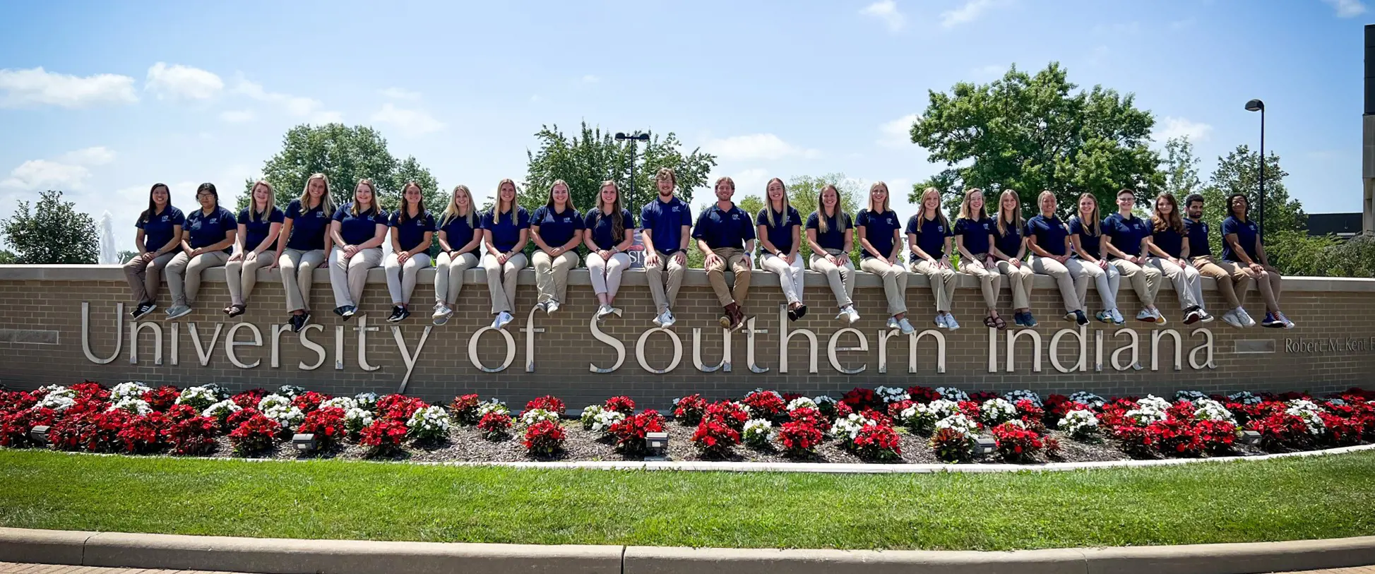 Class of 2022 cohort sitting on USI fountain