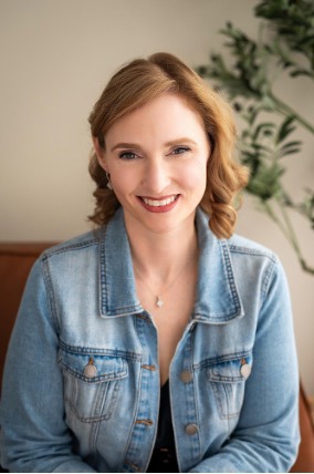 Woman wearing a faded blue jean jacket and smiling