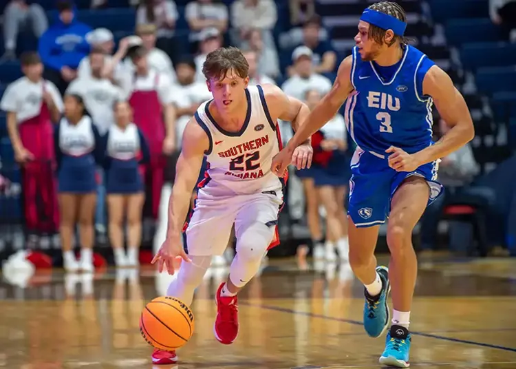 USI men's basketball player focuses while defending the ball from an opponent