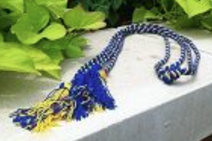 two royal blue and gold intertwined, knotted cords with knots and tassels on each end
