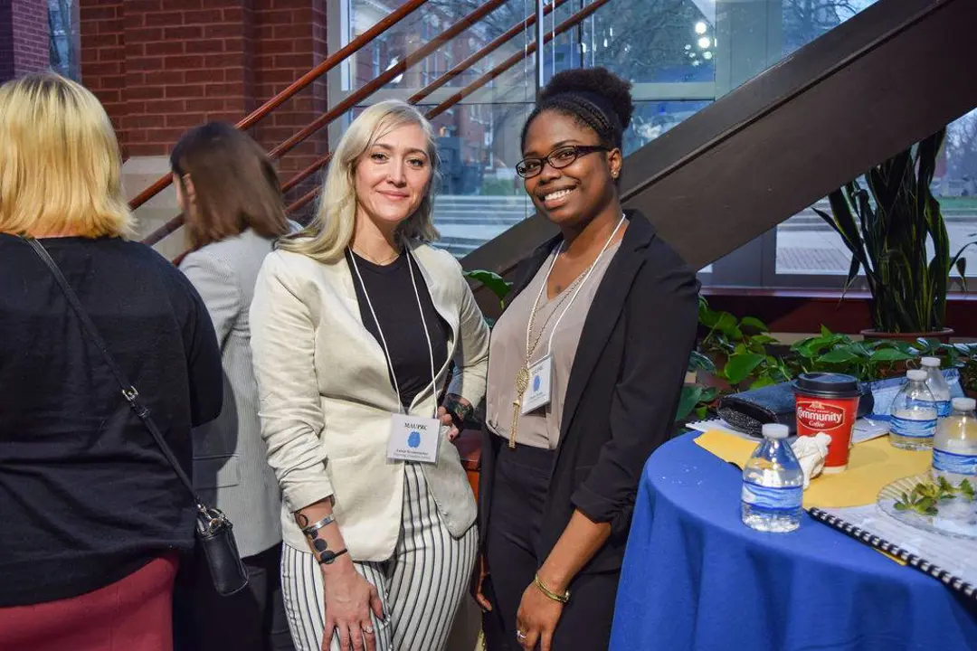 Psychology students in professional attire pose for a photo at a networking event