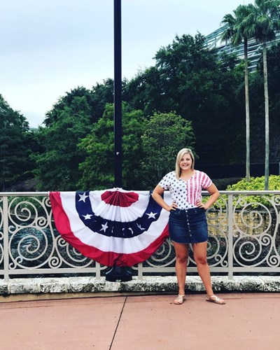 Mariah in front of a gate with a flag bunting