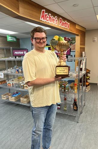Pack the Pantry Red team member posing with the winner's trophy.