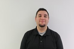 Portrait of Josh Kemp in black polo in front of white background