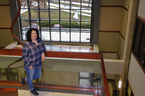 Shannon Hoehn stands on the landing of a stairwell in the Orr Center