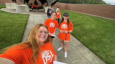 Nursing and health professions students pose for a photo in front of New Harmony's roofless church