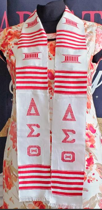 white stole with a red line design, the Asante/Ashanti golden stool symbol in red and the Delta, Sigma and Theta Greek letters in red on both sides