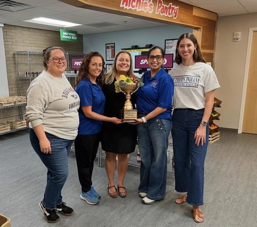 Pack the Pantry Red team members posing with the winner's trophy.
