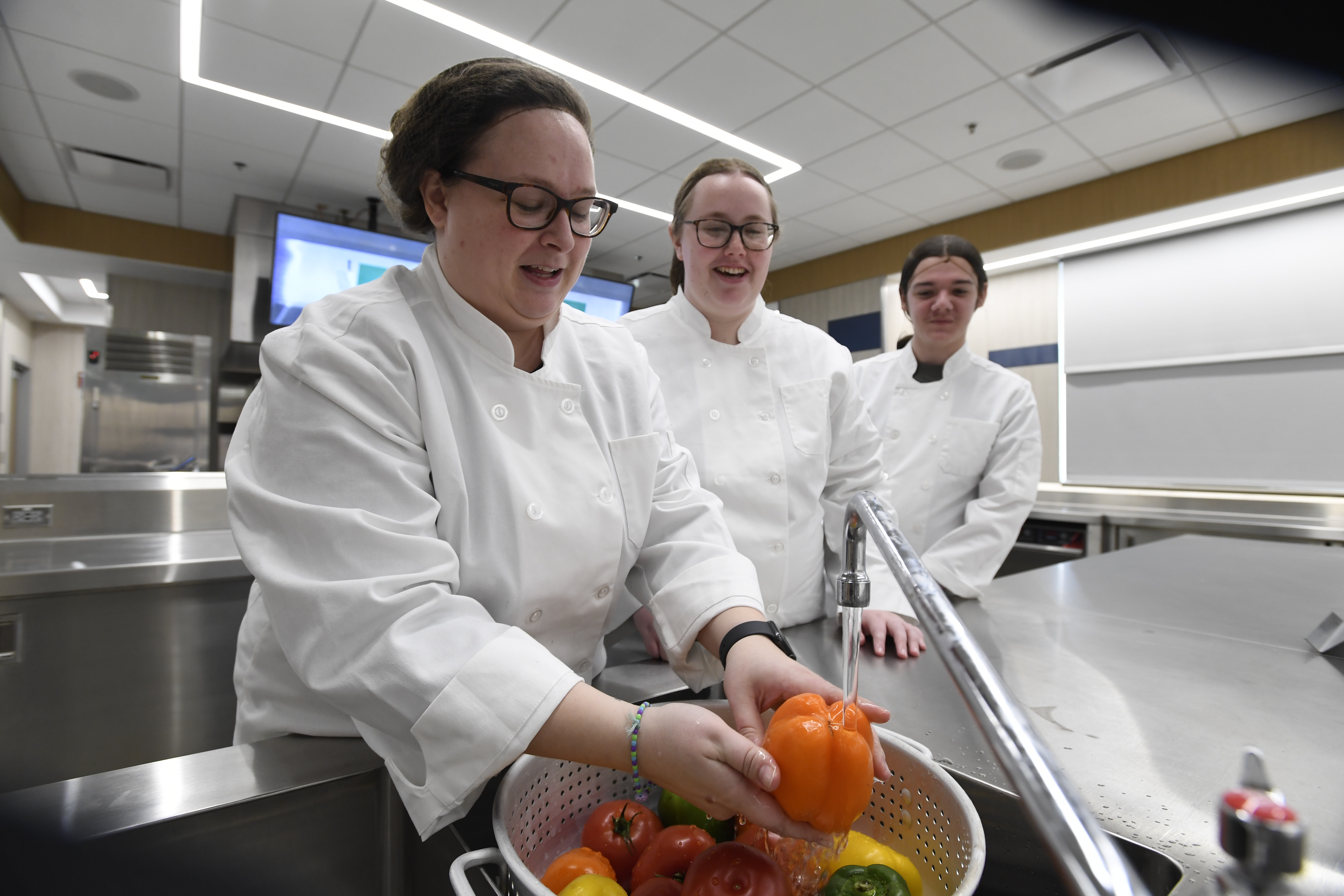 Students and faculty wash vegetables in the test kitchen