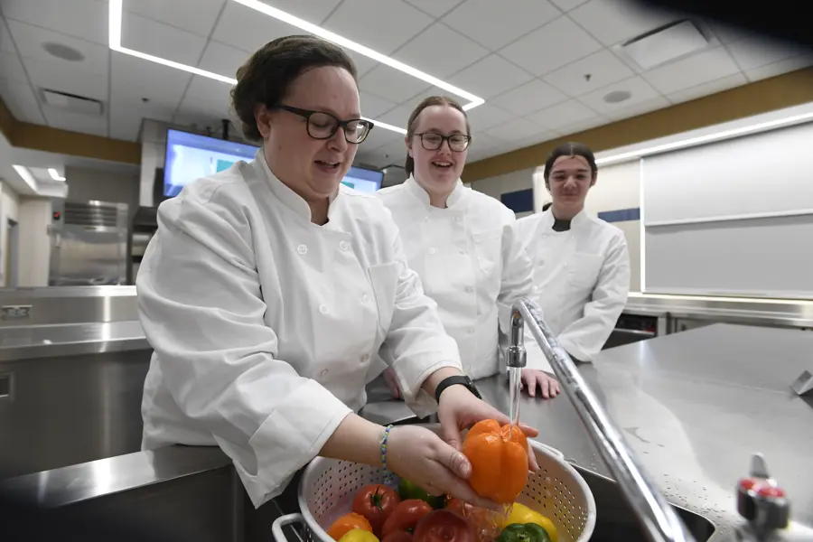 Students and faculty wash vegetables in the test kitchen