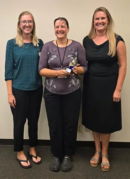 AHEC team members presenting trophy to clinical preceptor