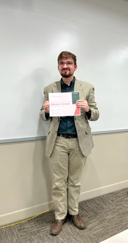 Spence Farmer posing with award at the English Awards Day Potluck