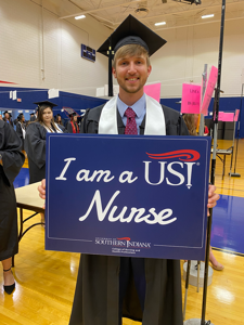 USI nursing grad holding sign