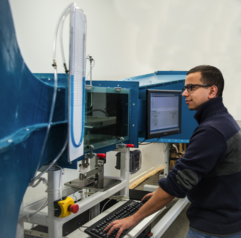 USI engineering student standing at a machine with safety glasses