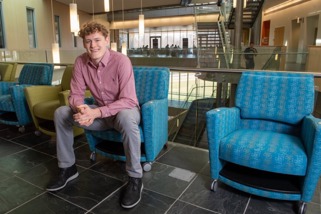 Jacob in a blue chair in the BEC atrium