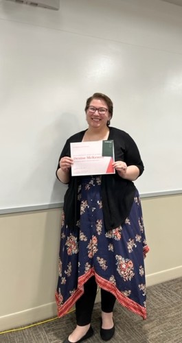 Denise McKenzie posing with award at the English Awards Day Potluck