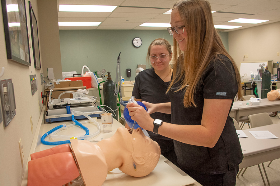 Students practice intubating a practice patient in a skills lab