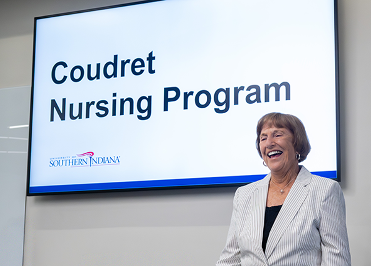 Photo of Nadine Coudret in front of sign that says "Coudret Nursing Program"