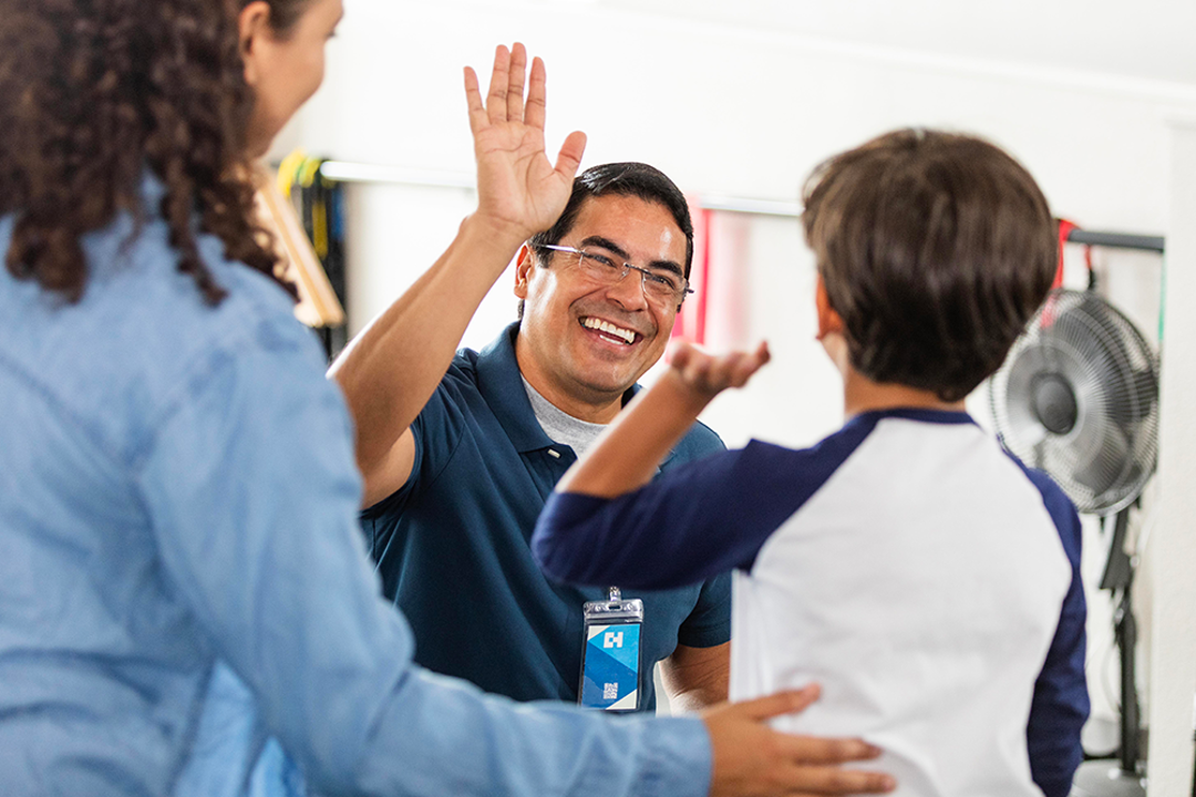 OT giving child a high five while mom watches