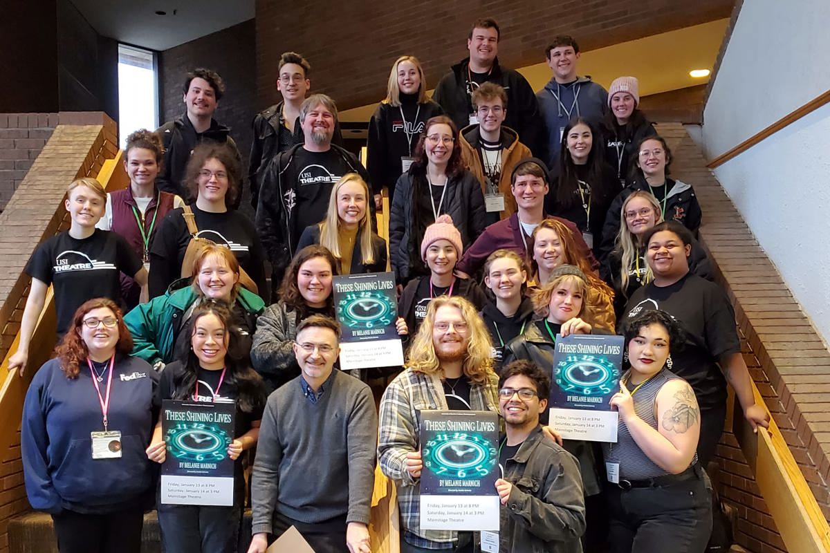 Students pose with These Shining Lives show posters at the American College Theatre Festival.