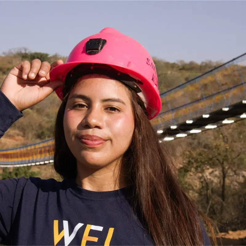 Melanie Cedeno wearing a hard hat with a bridge in the background