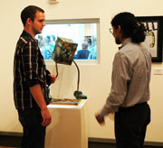 Alum Kyle Fitzgerald and art major Matt Perez discuss Matt's sculpture.