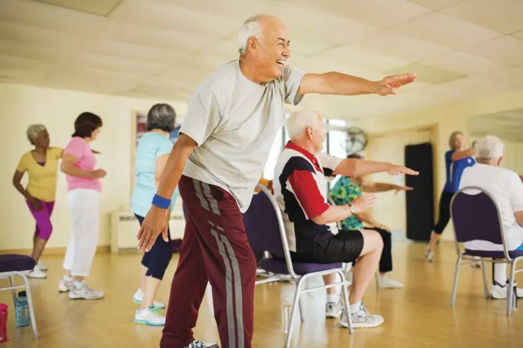 older adults stretching their arms participating in A Matter of Balance class