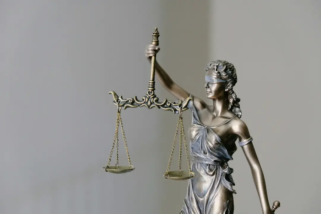 Small metal statue of a blindfolded woman holding the scales of justice
